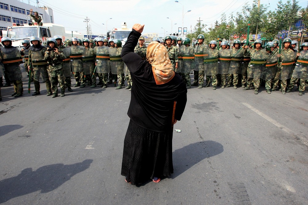 2009年7月7日，中國新疆烏魯木齊一名婦人面對一群防暴警察。（湯森路透）