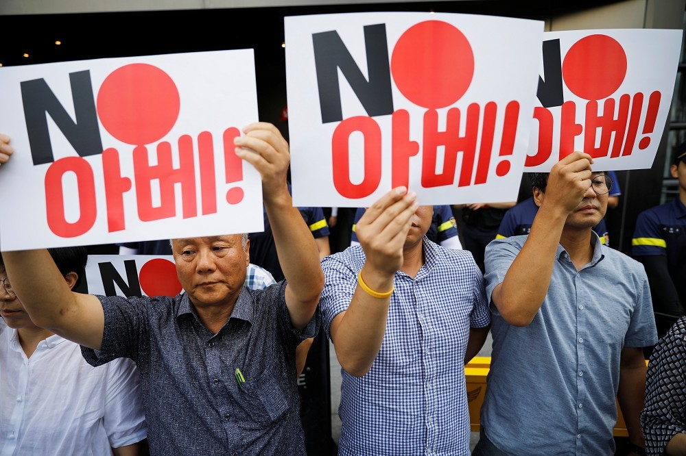 2日南韓首爾反日抗議者舉著「不要安倍（日本首相）」的牌子。（湯森路透）