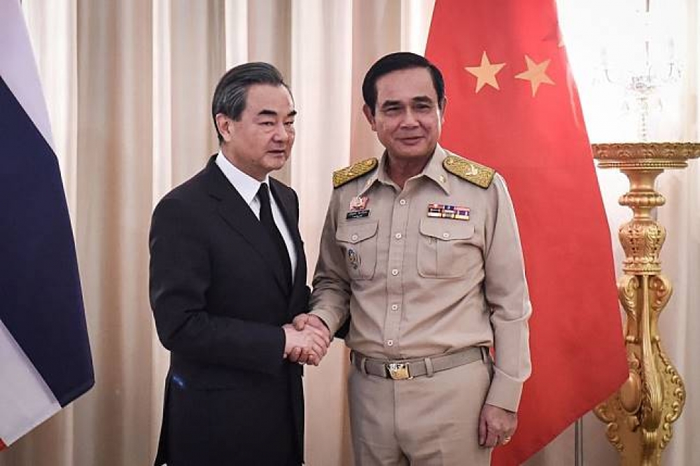 泰國總理帕拉育（右）24日在泰國首都曼谷會見中國外交部長王毅（左）。（湯森路透）