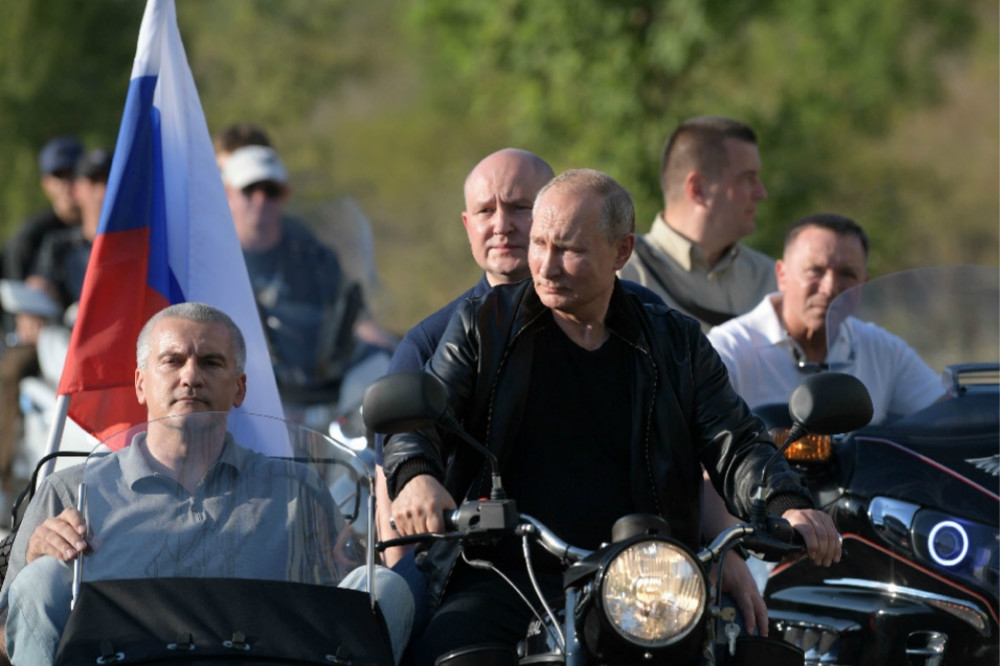 俄羅斯總統普京（圖中央）親自駕駛雙載摩托車，載著克里米亞兩名地方領袖前往會場。（湯森路透）