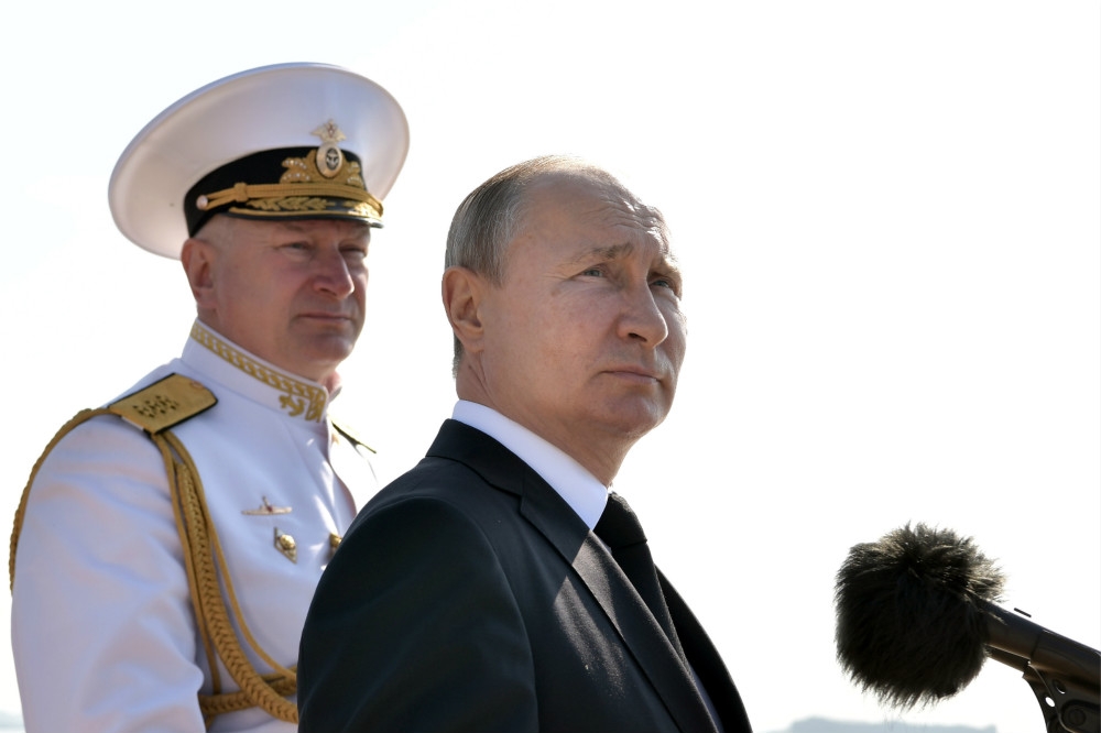 俄羅斯總統普京（右）在海軍將領陪同下，出席校閱海軍艦艇。（湯森路透）