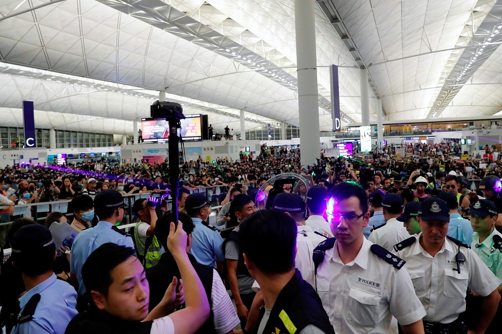 香港機場13日再度爆發示威者與警察的衝突。（湯森路透）