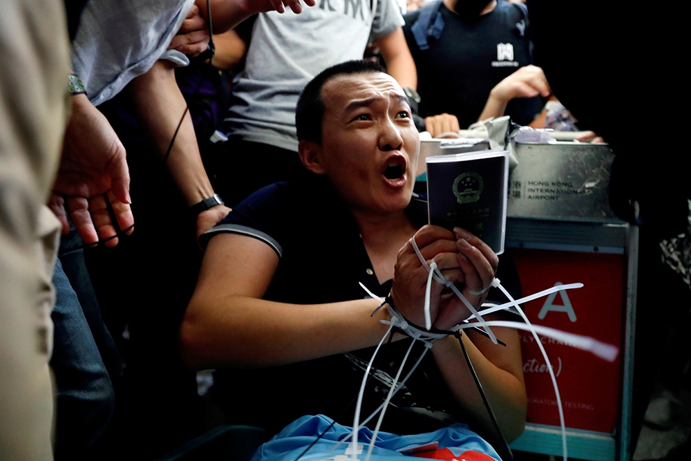 中國《環球時報》記者付國豪在香港機場被示威者綑綁。（湯森路透）