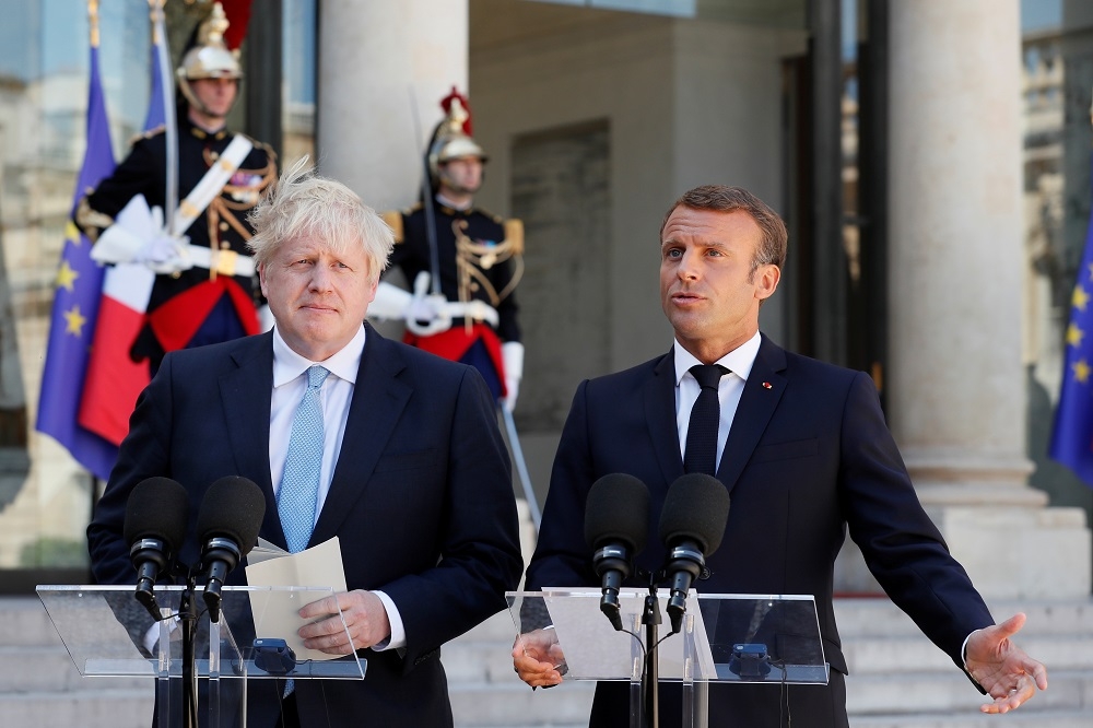 英國首相強森（左）與法國總統馬卡洪（右），在巴黎針對脫歐議題舉行會晤。（湯森路透）