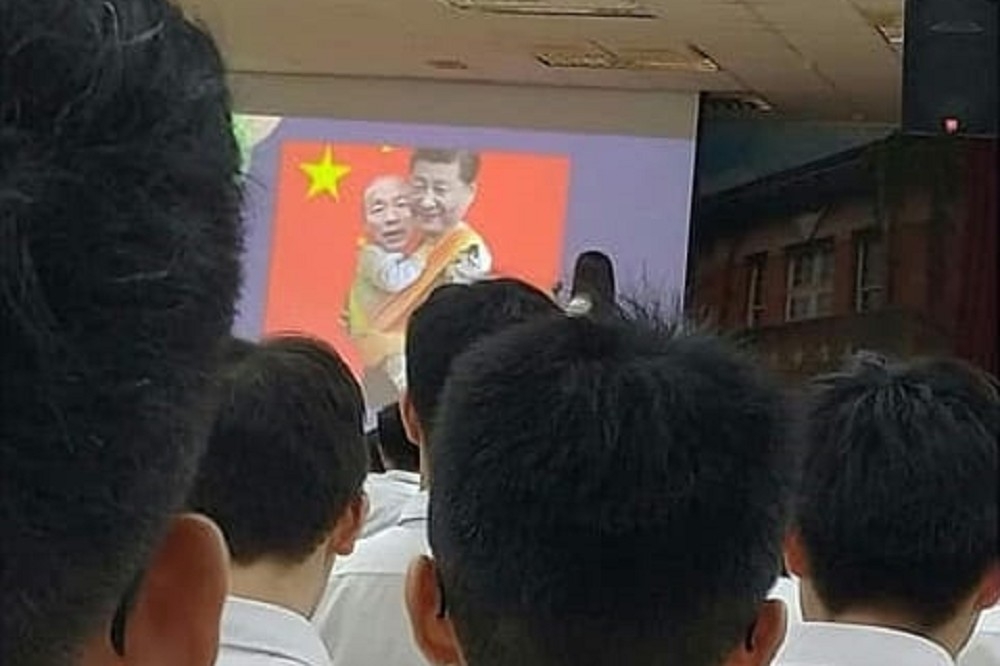 高雄中學28日新生始業輔導社團展期間 ，驚現學生播放中國共產黨主席習近平抱著韓國瑜，背景則是中國國旗「五星旗」的圖片。（圖片取自韓國瑜粉絲團臉書）