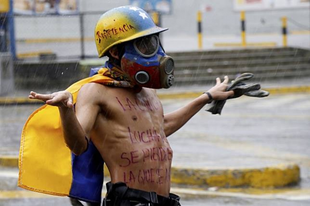 反對總統馬杜洛執意設立制憲大會、重新起草憲法的委內瑞拉民眾28日在雨中抗議。（美聯社）