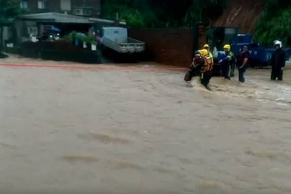 新北市三芝區淡金路受到大雨災情的影響，目前馬路已變成湍急的河流。 （新北市消防局提供）