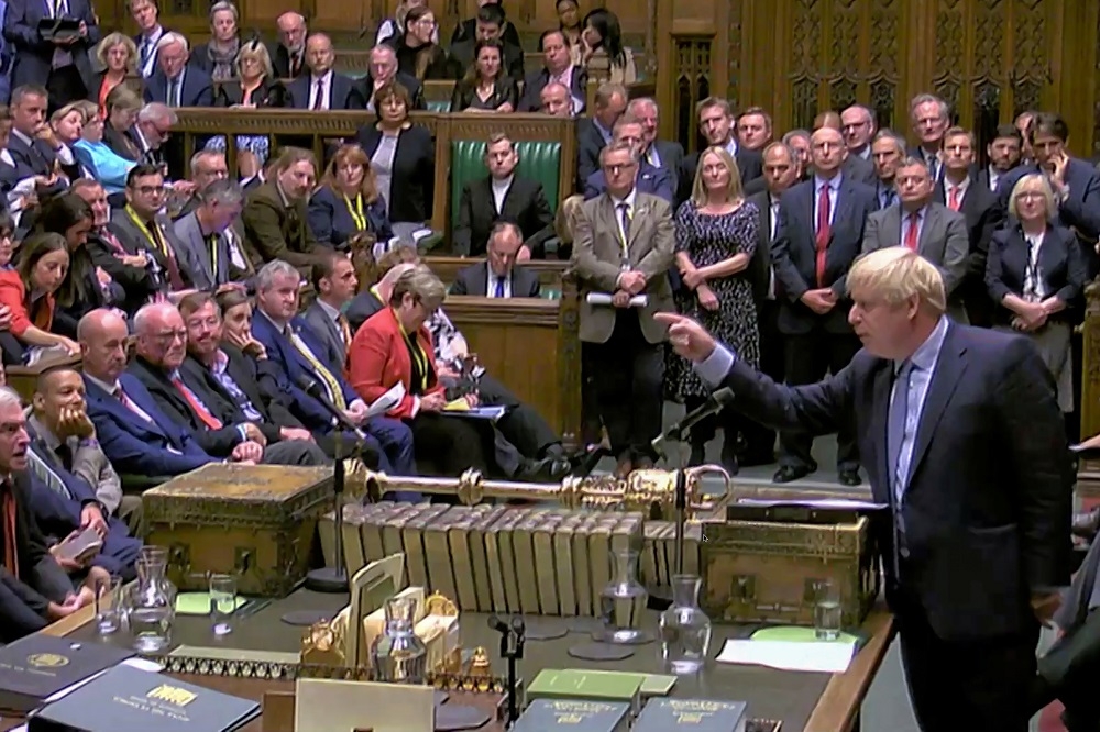 英國首相強森（Boris Johnson）與國會議員談話。（湯森路透）