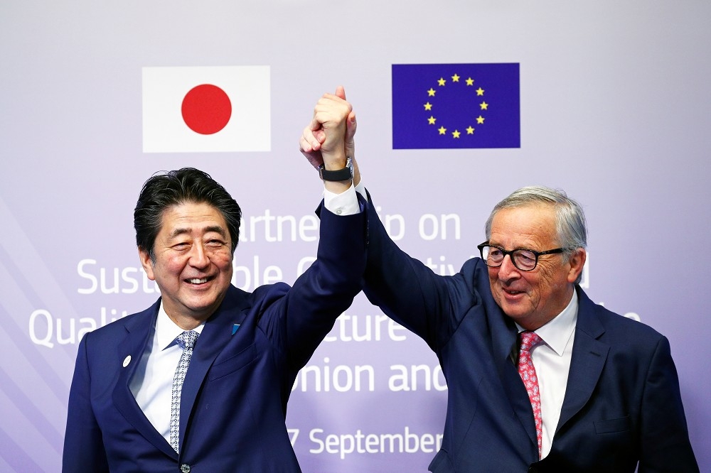 歐盟執委會主席容克（右）與日本首相安倍晉三（左）27日參與歐亞連結論壇，並簽署協議。（湯森路透）