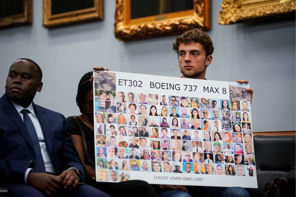 一名衣航罹難者家屬手持看板前往美國國會，要求華府介入調查還給他們真相。（湯森路透）