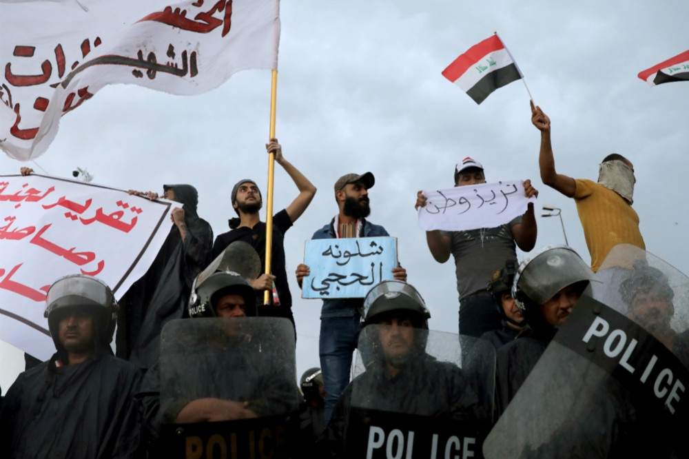 伊拉克警察與反政府抗爭群眾。（湯森路透）