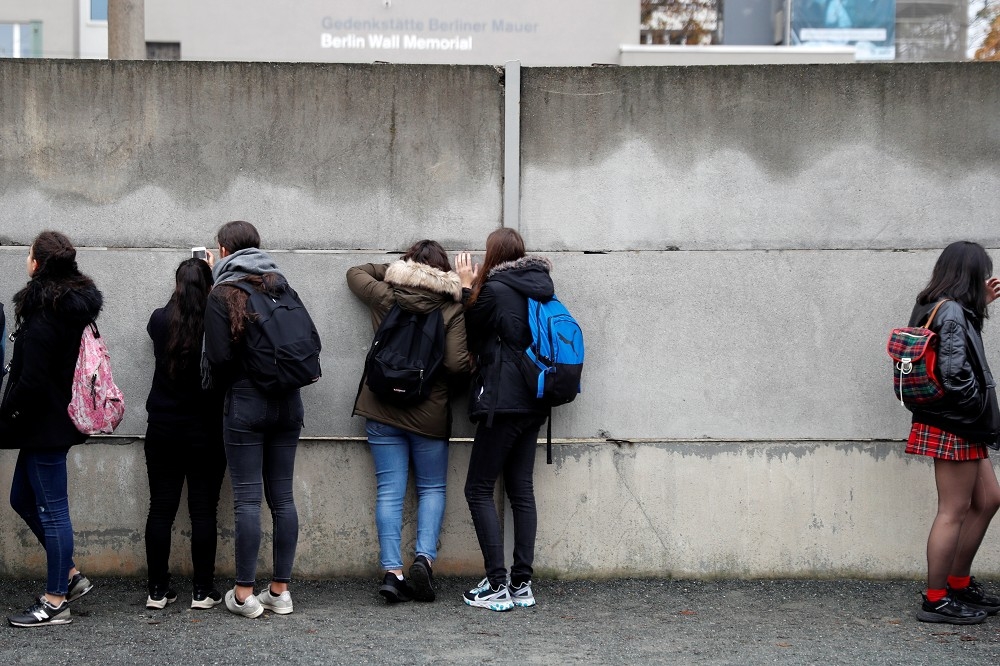德國年輕人佇足柏林圍牆遺跡前。（湯森物透）