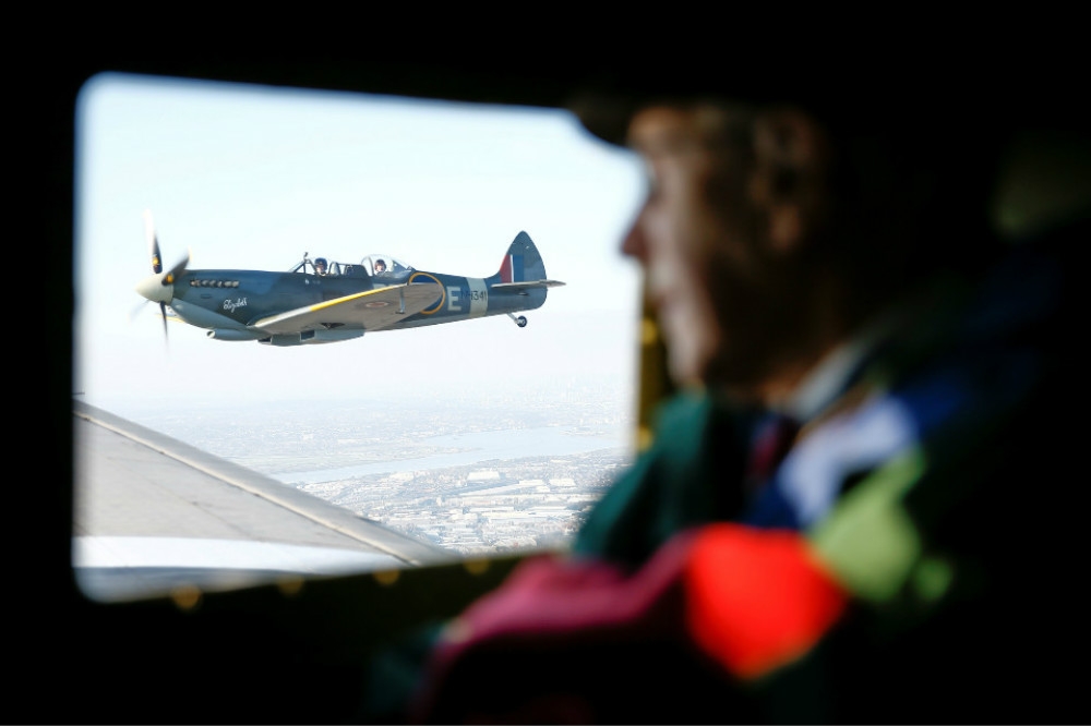 二戰退役老兵搭乘C-47運輸機，在多佛上空與噴火戰機揮手致意。（湯森路透）