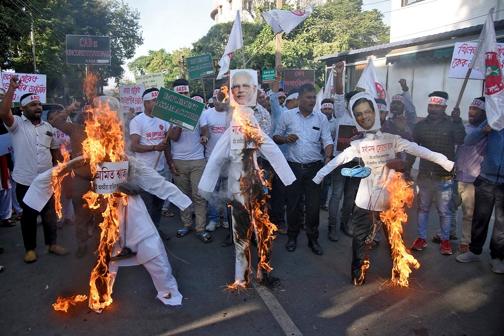 阿薩姆邦抗議者4日焚燒印度總理莫迪等官員立牌。（湯森路透）