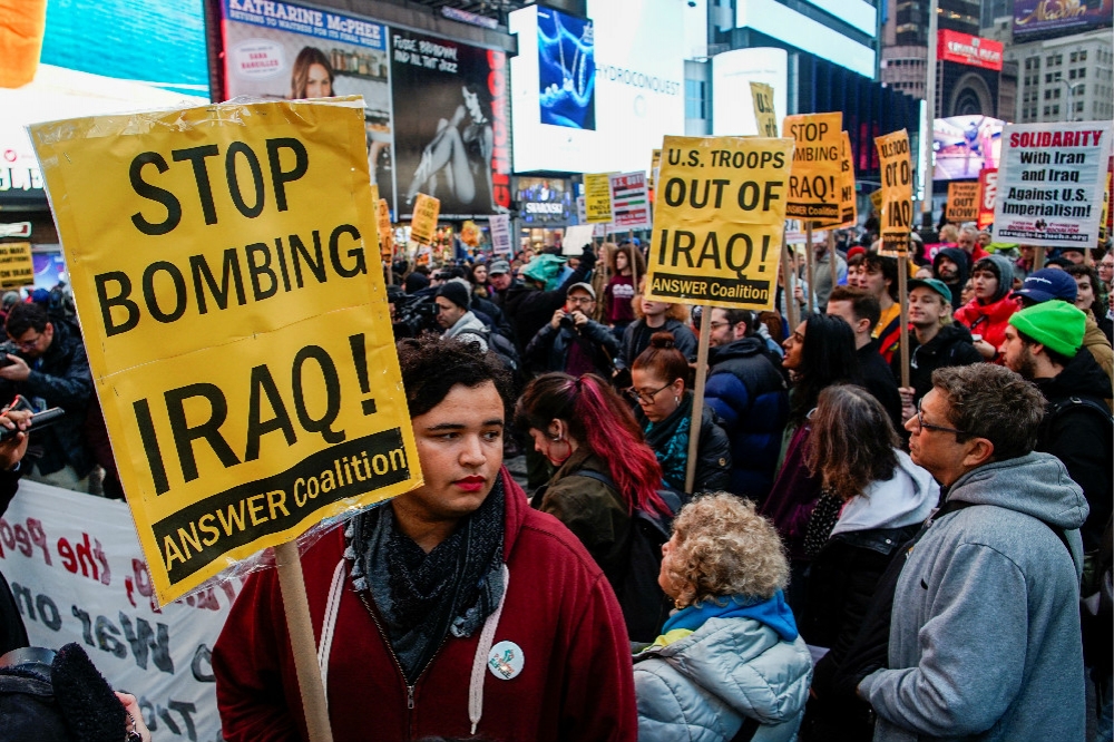 大批群眾聚集紐約時代廣場，高舉標語、呼喊口號，要川普不要再攻擊與插手伊拉克事務。（湯森路透）