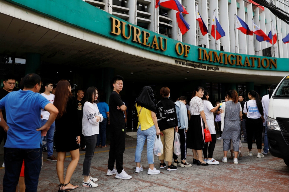 大批中國旅客在菲律賓移民署大樓前排隊。（湯森路透）