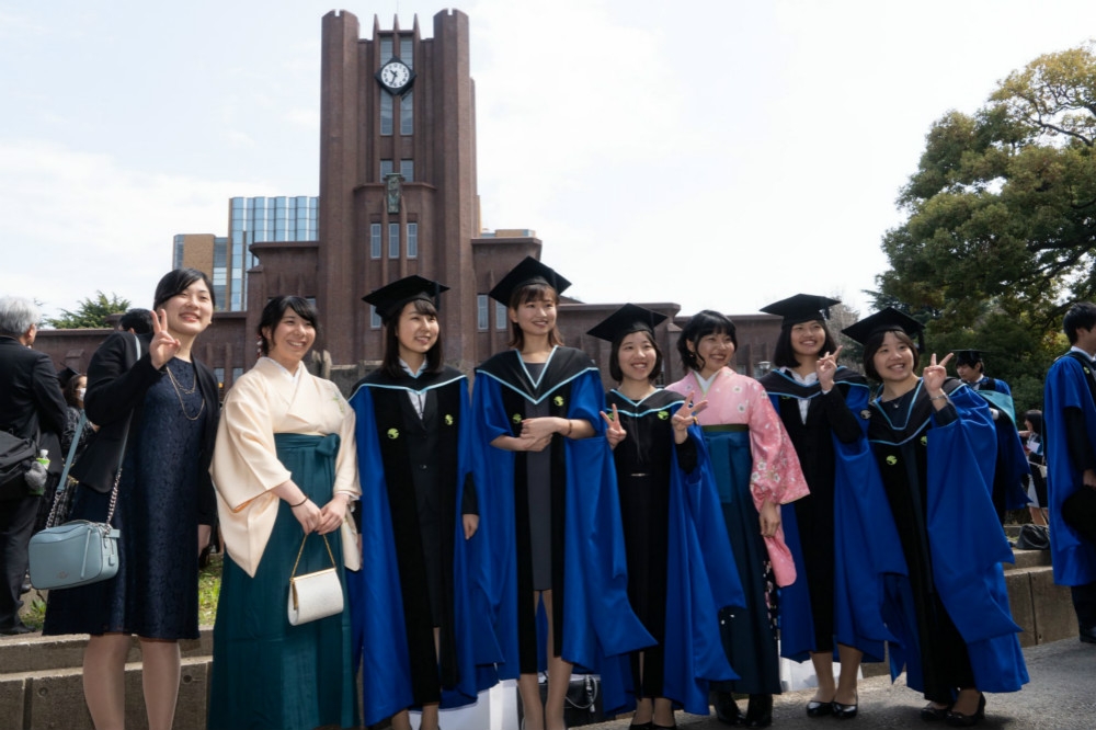 在地標大樓前拍攝畢業照的東京大學畢業生。（圖片取自東大臉書）