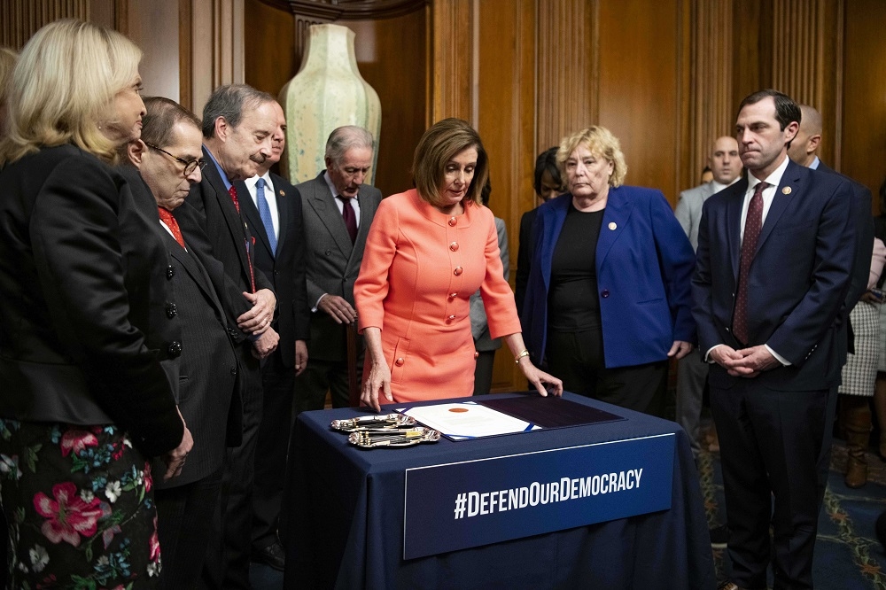美國眾議院議長裴洛希（Nancy Pelosi）15日簽署彈劾文件。（湯森路透）