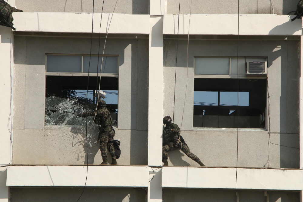 陸戰特勤隊模擬大樓遭暴徒占領並挾持人質，他們以爆藥破窗後突入內部，迅速壓制暴徒。（王侑聖攝）