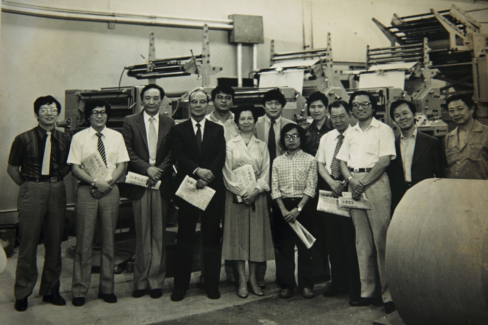 《美洲中國時報》於1982年9月1日正式發刋。余紀忠董事長（左四）在紐約總部印刷廠與同仁一起迎接第一份報的誕生。圖右二是黃肇松。是他參加報紙實務工作的開始。。（圖片由作者提供）