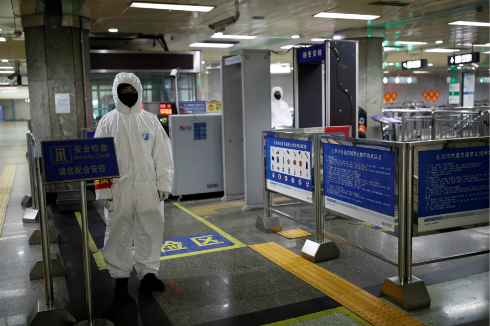 一名北京地鐵工作人員全副武裝進行防疫保護。（湯森路透）