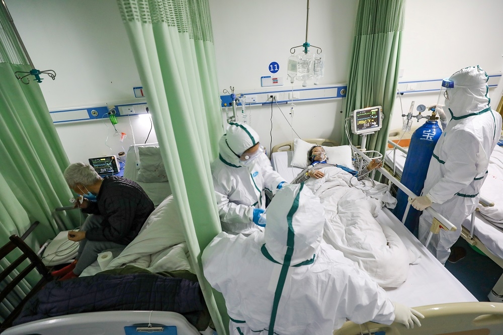 武漢醫護人員照顧隔離病房的患者。（湯森路透）