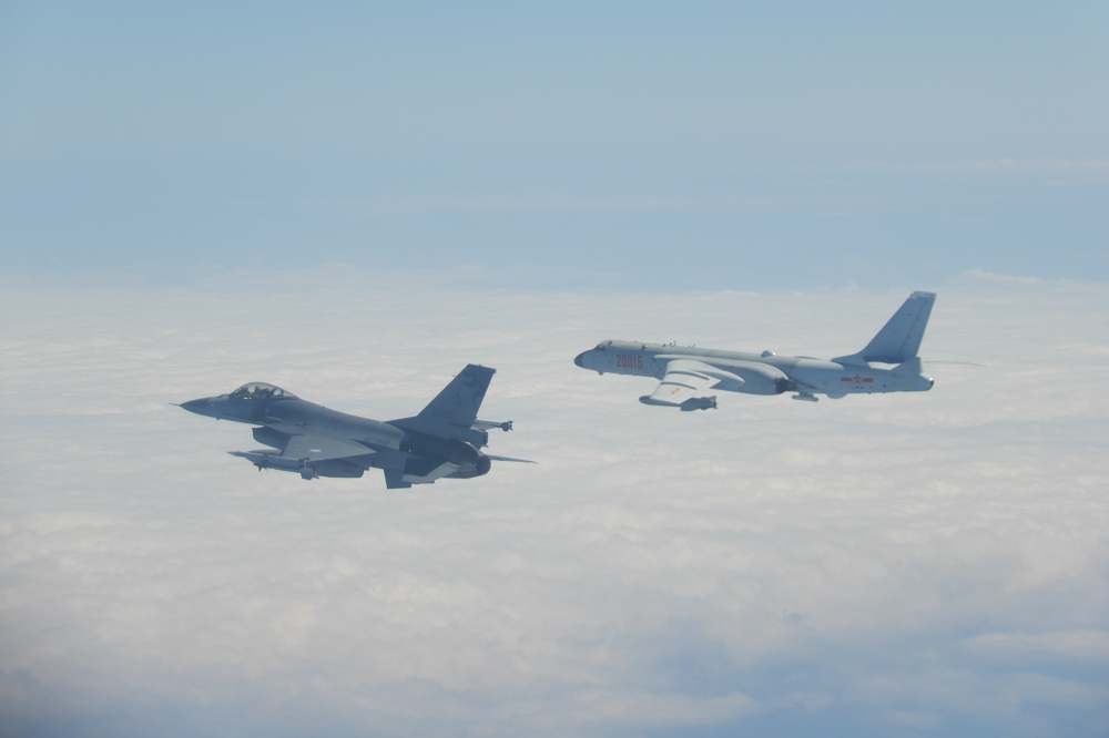 中共軍機「轟6」（右）在進行遠海長航訓練，對此我國派出空中偵巡機及防空部隊（左方F-16）適切應處。（國防部提供）