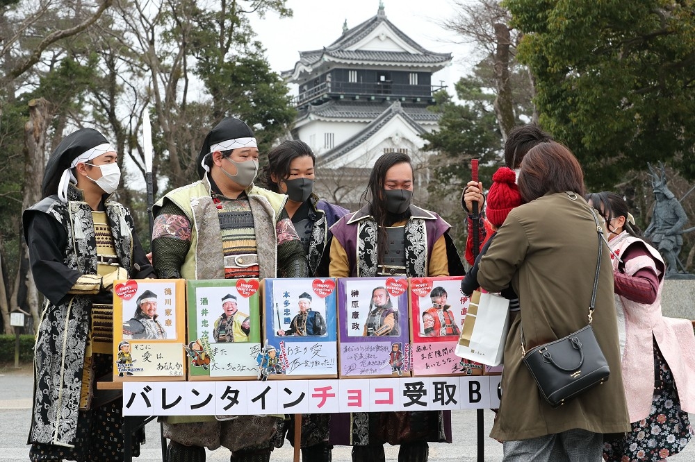日本愛知縣岡崎城外面的情人節活動，工作人皆戴著口罩。（湯森路透）