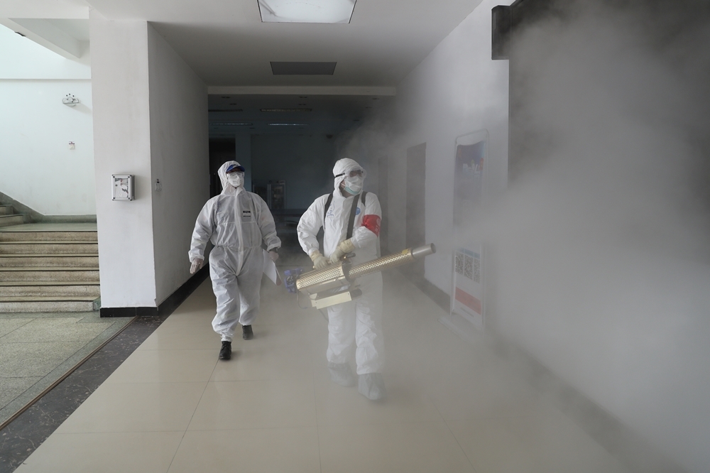 2020年2月22日，穿著防護服的志工正在為武漢的一處住宅區進行消毒（湯森路透）