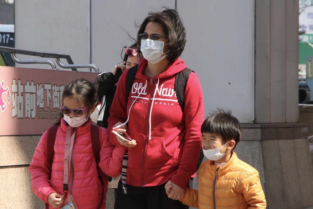 台北街頭，一位母親和她的兩個小孩戴著口罩（資料照片／王侑聖攝）