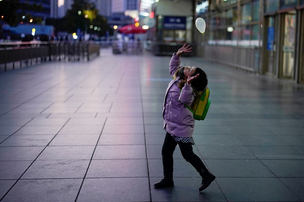 上海一名小女生在與氣球玩耍。（湯森路透）