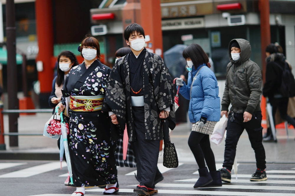 隨著肺炎疫情持續升溫，日本民眾也紛紛戴起口罩防疫。（湯森路透）
