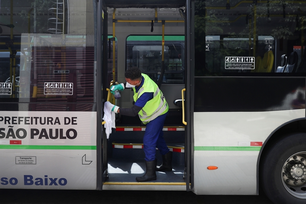 巴西聖保羅的一名清潔人員正在為公車進行消毒（湯森路透）