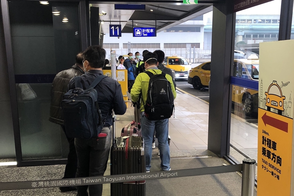 從桃園機場返國的民眾排隊搭乘防疫計程車（資料照片／王侑聖攝）