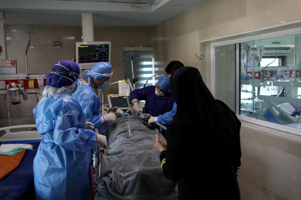 伊朗重症病房內全副武裝的醫護人員和病患。（湯森路透）