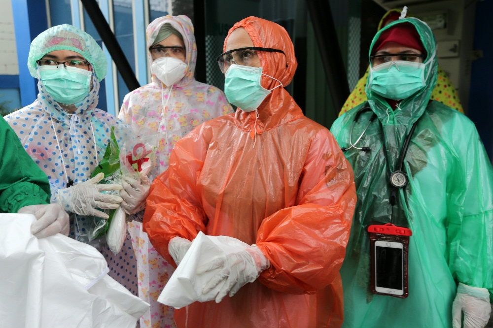 防護設備匱乏的印尼、許多醫護人員被迫用垃圾袋改為防護衣替代使用。（湯森路透）