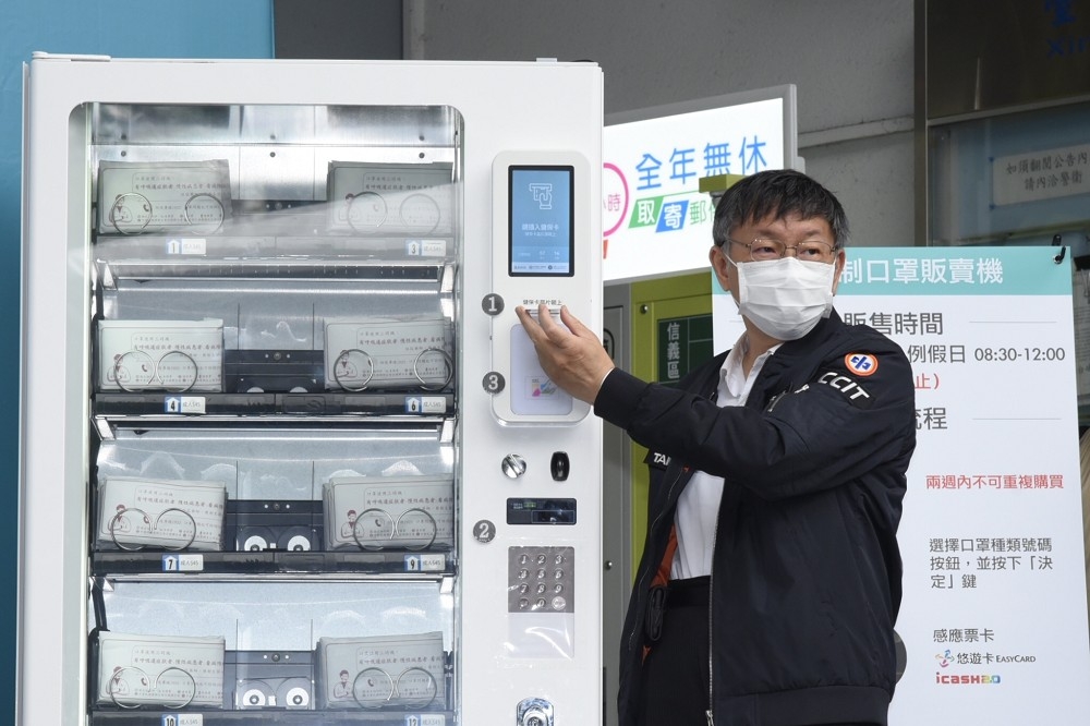 北市口罩販賣機試營運一個月，台北市長柯文哲示範如何使用販賣機。（蔣銀珊攝）