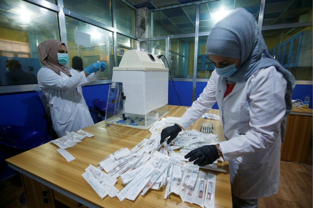 伊拉克防疫人員正在整理快篩試劑。（湯森路透）