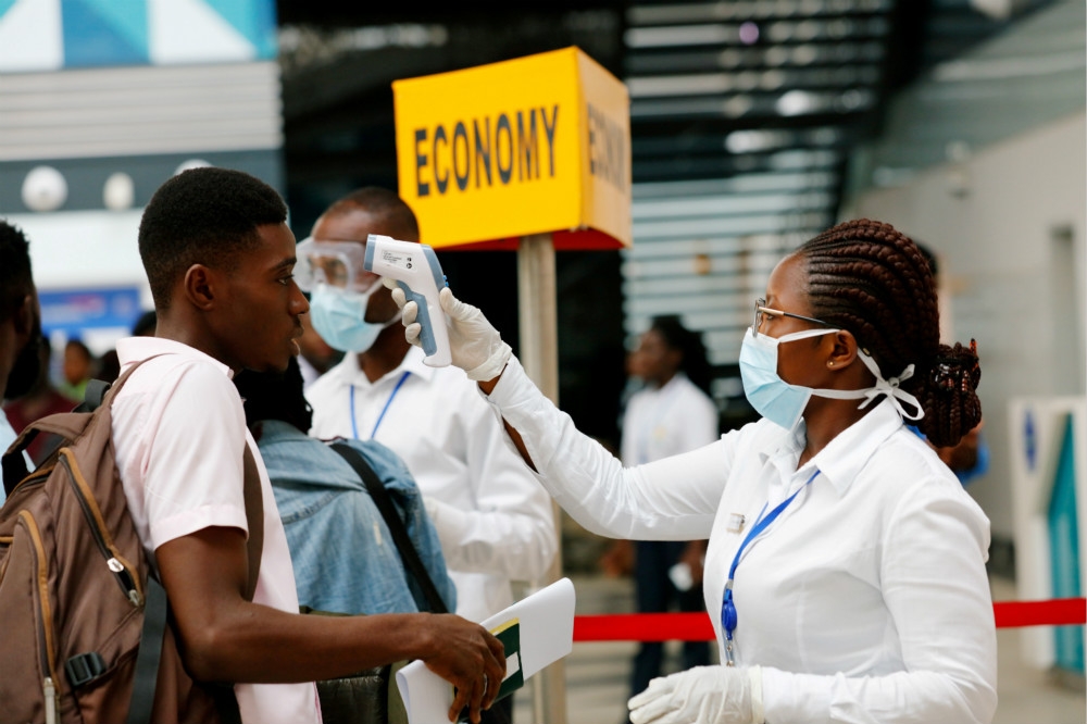迦納首都阿克拉機場替旅客測量體溫。（湯森路透）