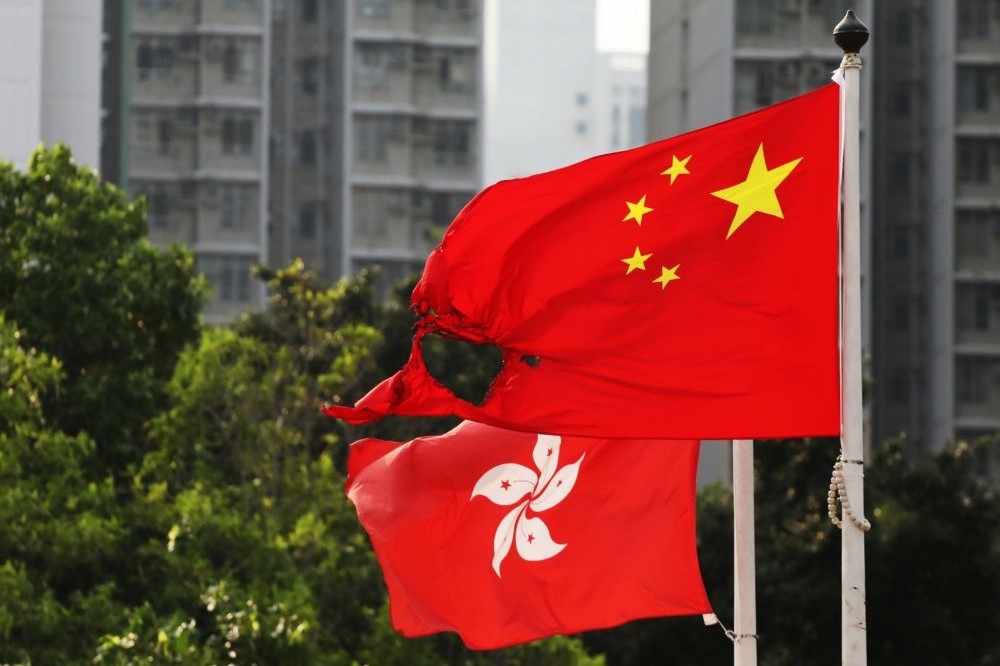 2019年10月13日，遭部分焚毀的中國五星旗飄揚在香港黃大仙區的旗桿上。（湯森路透）