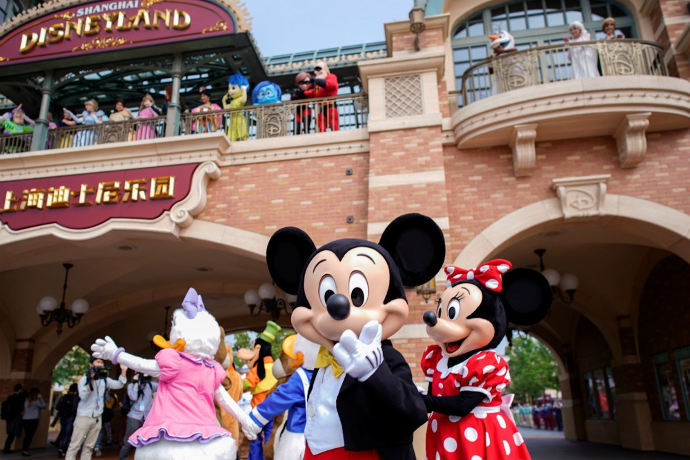 米奇、米妮與數十名迪士尼人物共同歡迎，睽違3個月後首批入園的遊客。（湯森路透）