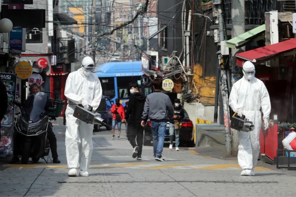 群聚傳染再度爆發，南韓防疫人員前往梨泰院消毒。（湯森路透）