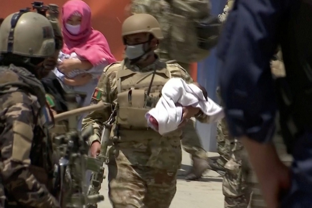 阿富汗一處醫院12日遭到槍手攻擊，一名軍人從產科救出嬰兒。（湯森路透）