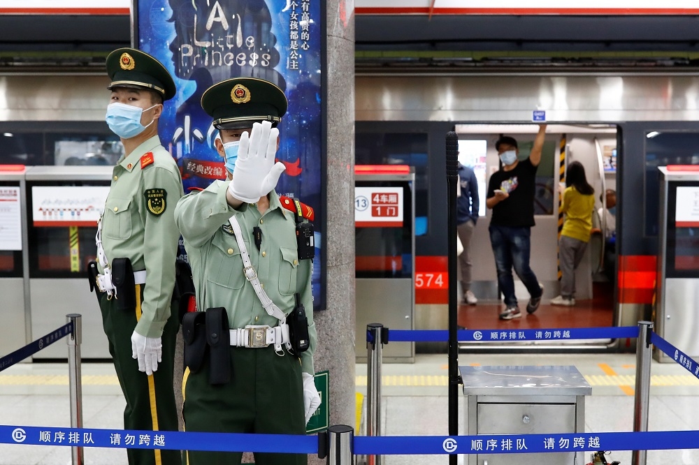 兩會準備期間，北京人民大會堂附近地鐵站的駐站警衛以手勢阻止攝影師拍攝。（湯森路透）