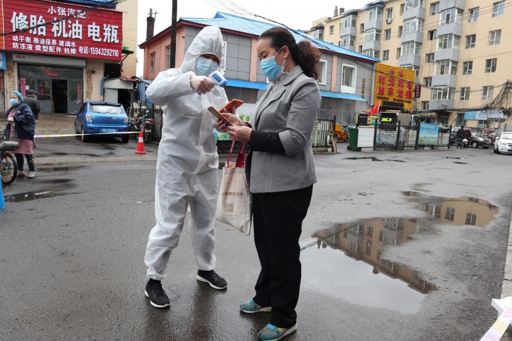 中國吉林省防疫人員正在掃描市民的外出碼。（湯森路透）