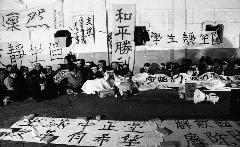 「我們怎能再容忍七百個皇帝的壓榨」，1990年3月16日，9名台大學生於台北市中正紀念堂外「大中至正」的牌樓下拉起了白布條，靜坐抗議將近半世紀未曾改選的七百多位資深國大代表，拉開野百合學運序幕。（攝影：蔡明德）