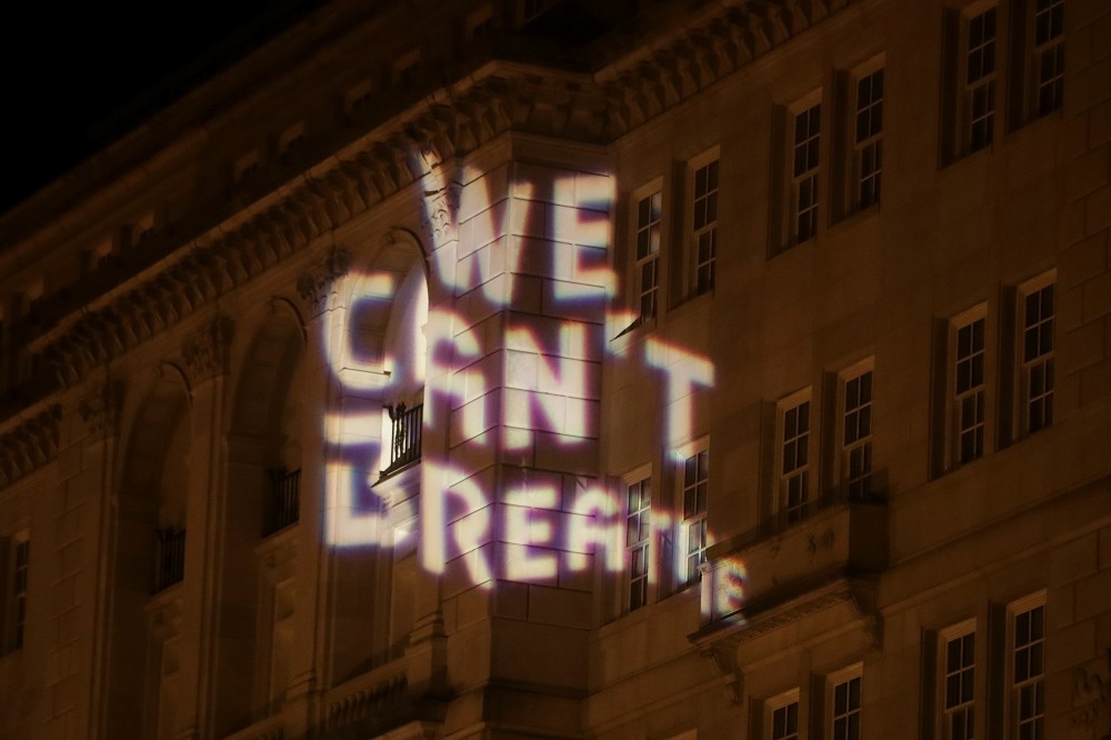 示威民眾在華盛頓特區的大樓上投影「We can't breathe」，抗議佛洛伊德的死亡。（湯森路透）