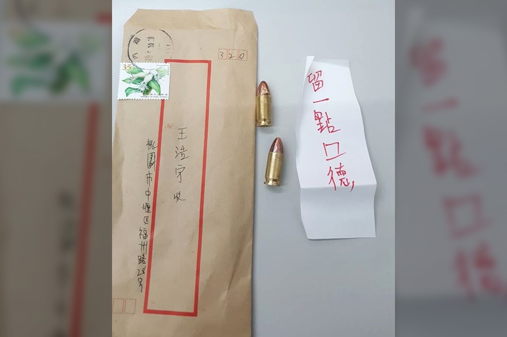 王浩宇12日在臉書貼出一張照片，表示自己收到「兩顆子彈」，還有一張用紅筆寫著「留一點口德」的字條。（取自王浩宇臉書）