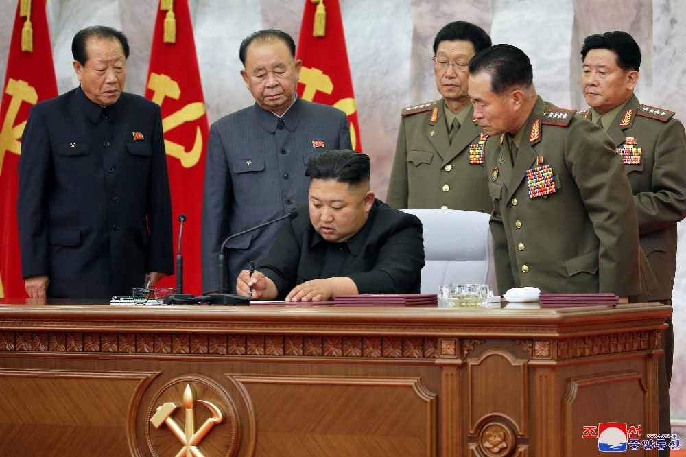 北韓領導人金正恩（中央）和軍方高層將領開會。（湯森路透）