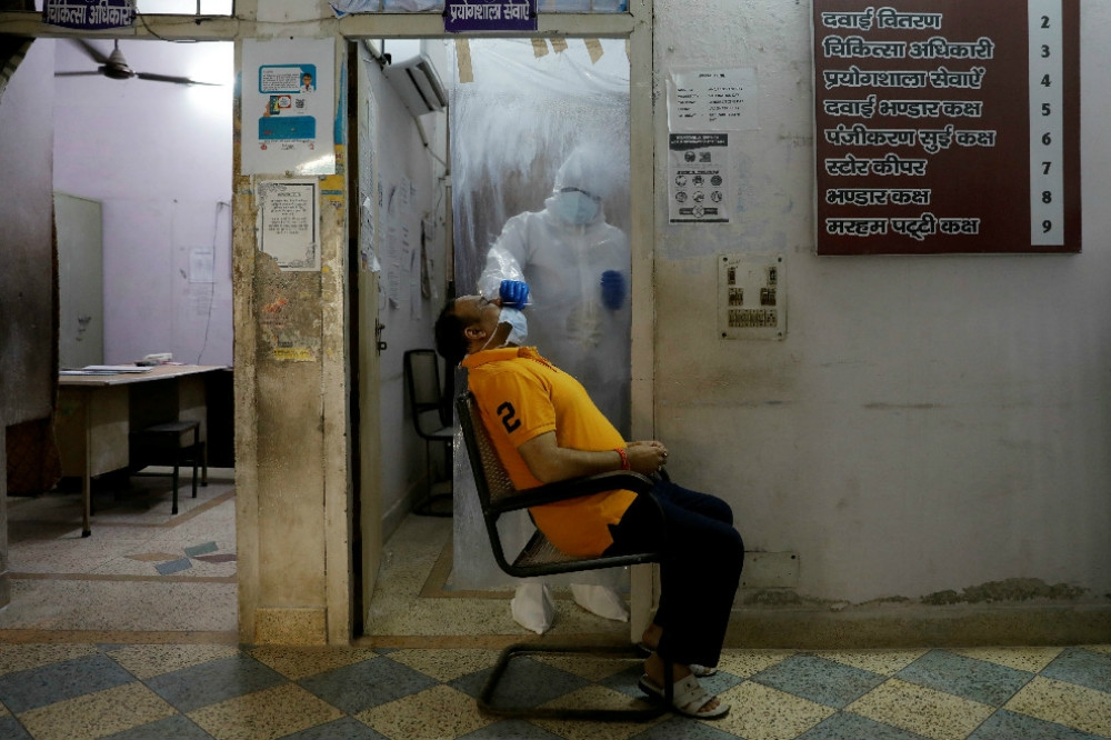 全球第四大疫區的印度，醫護人員正在對民眾進行檢疫工作。（湯森路透）